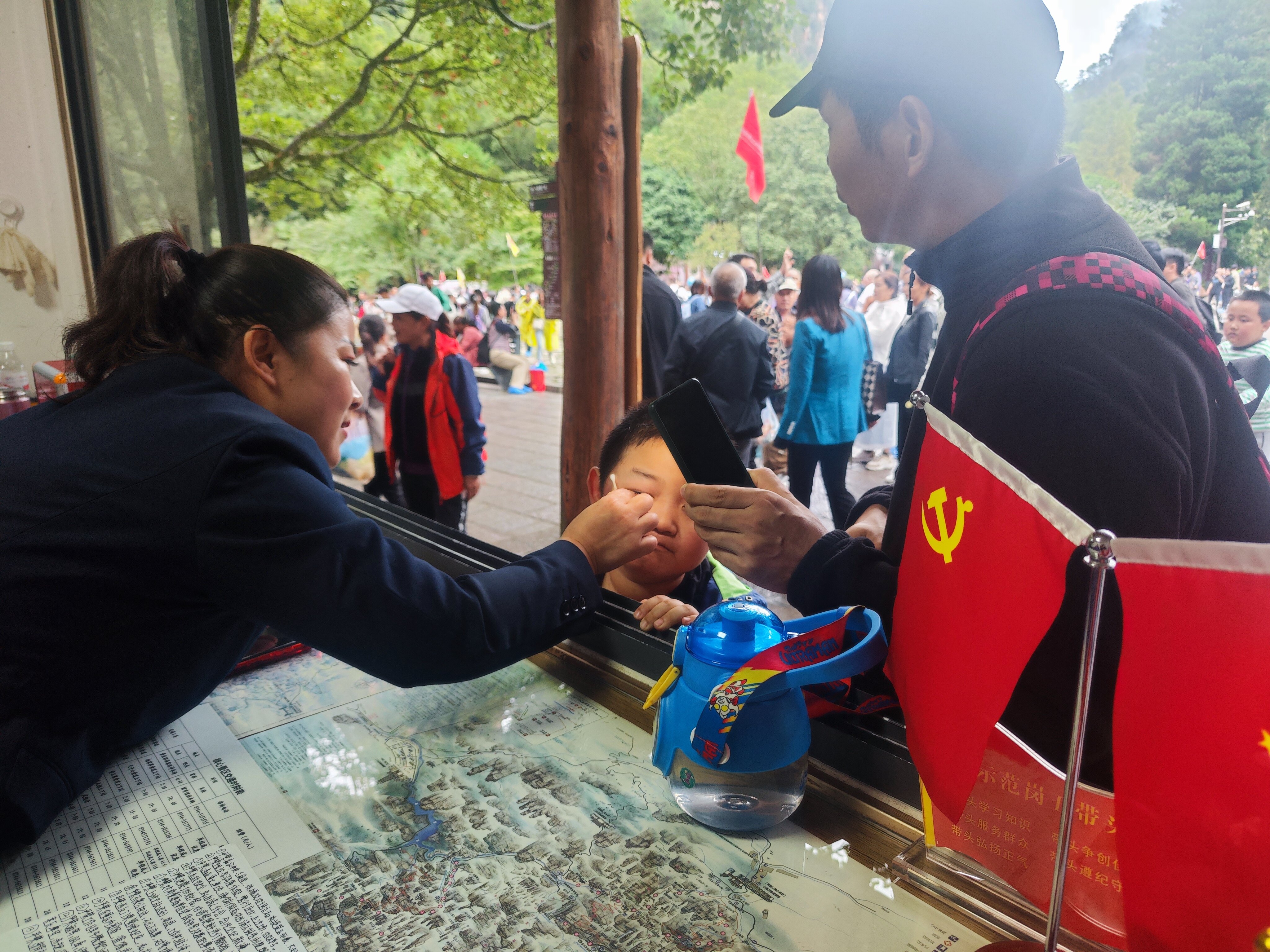 老磨灣黨員義務(wù)咨詢臺(tái)黨員為小游客處理被蜜蜂蟄傷傷口。張娜 攝